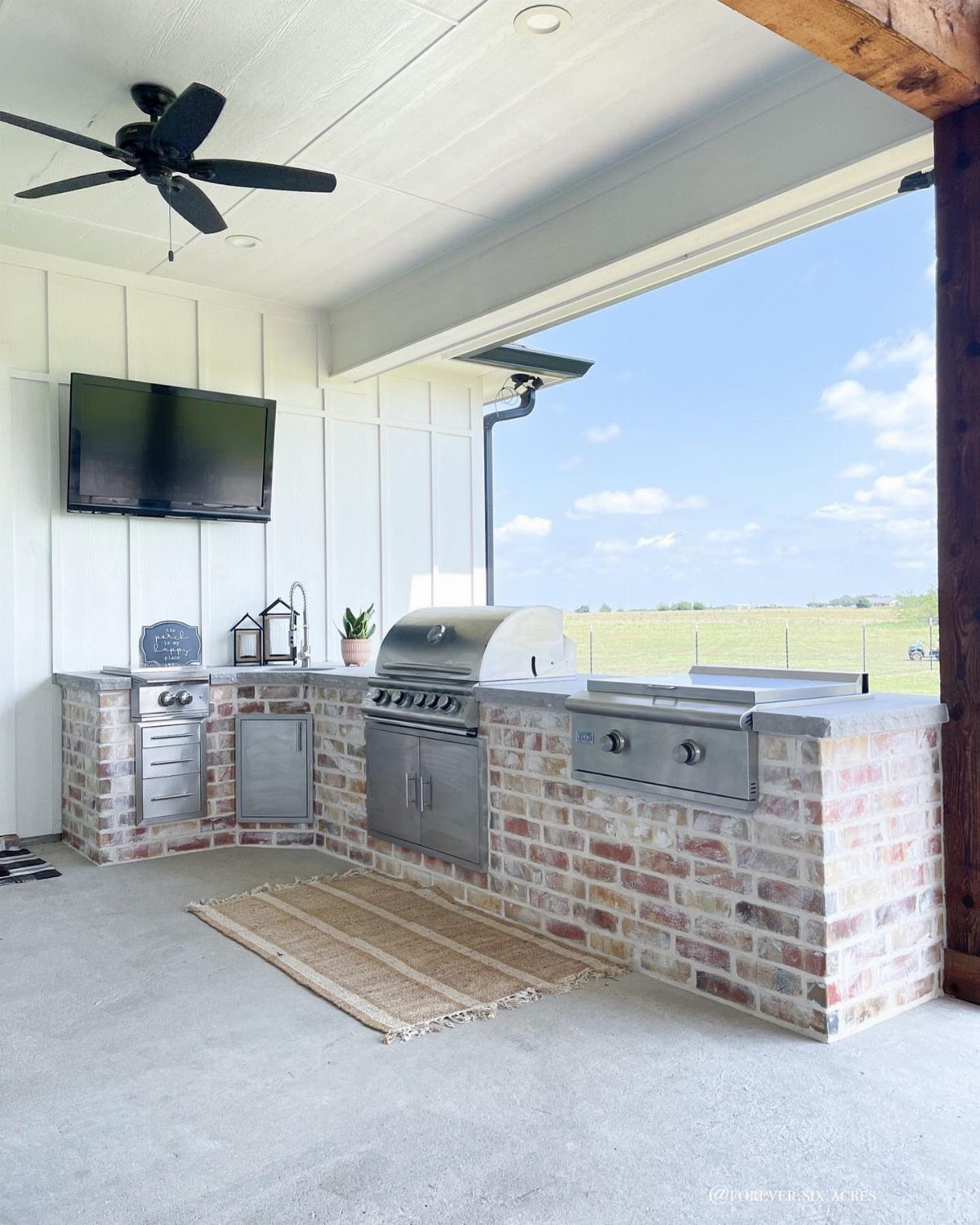Backyard Barbeque Design: 12 BBQ Island Ideas for Outdoor Cooking 7 Brick outdoor kitchen island with stainless steel grill and appliances under a white patio ceiling.