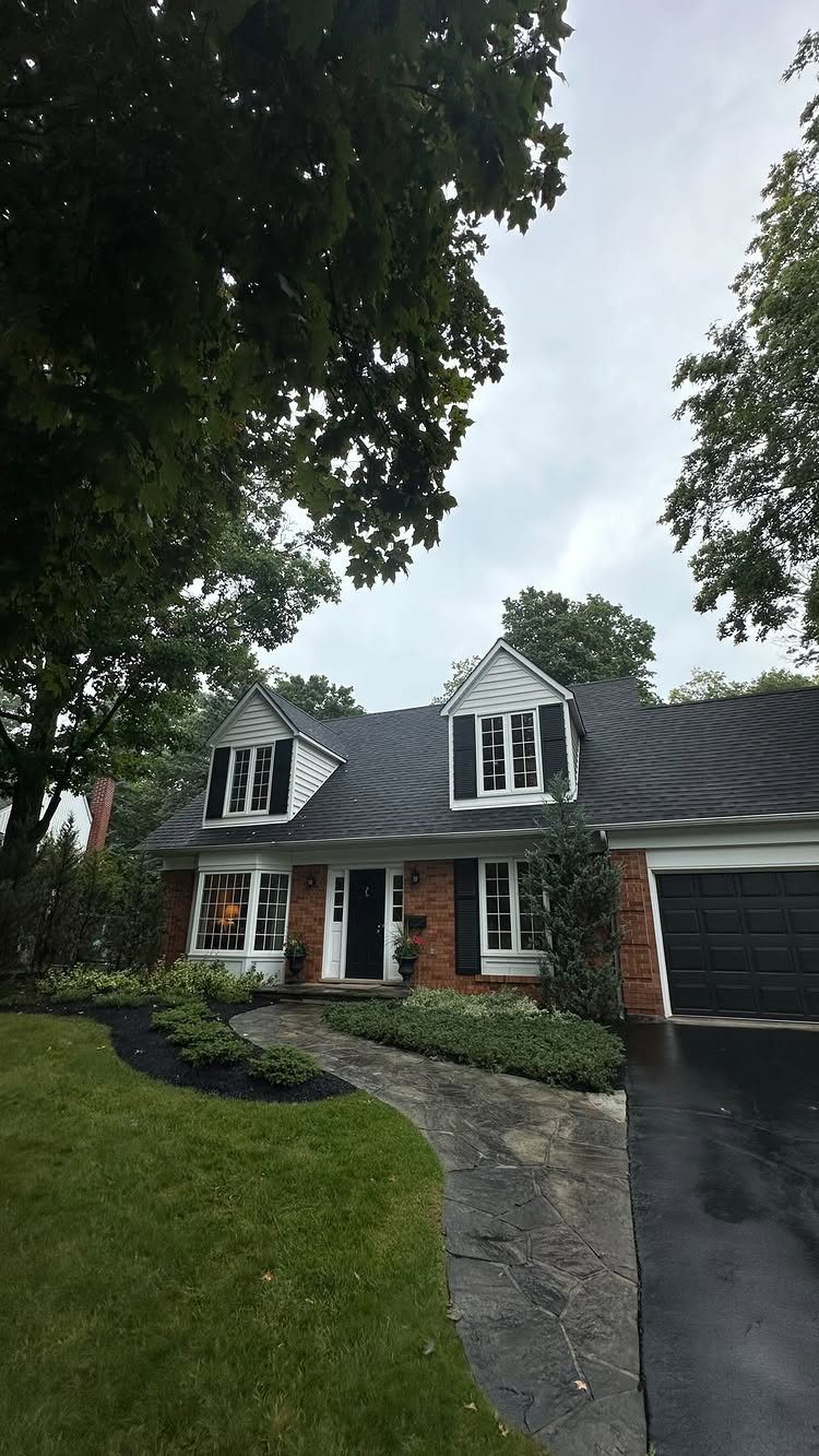 9 Cape Cod House Exterior Ideas for Curb Appeal 2 A Cape Cod house featuring two white dormers with black shutters on a dark roof.