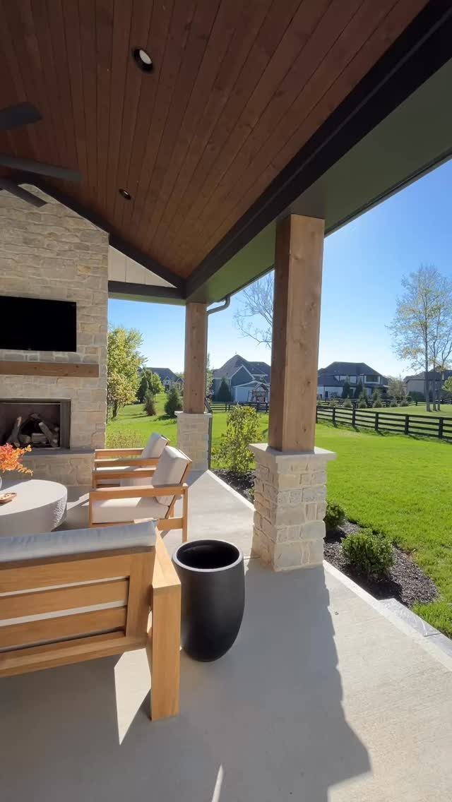20 Covered Patio Ideas for Shade, Style and Year-Round Use 4 Stone outdoor fireplace with a television mounted above it on a covered patio.