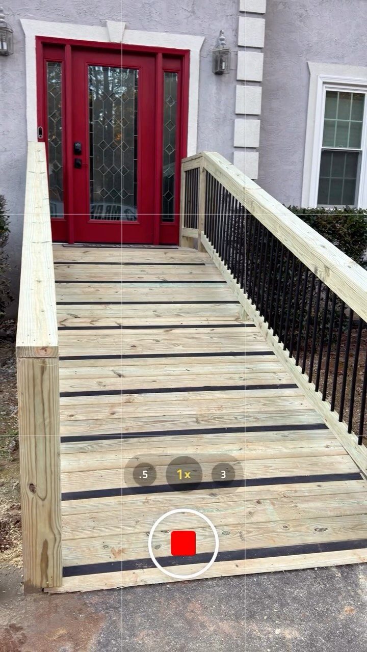 4 Deck Ramp Ideas for Every Yard and Budget 3 Wooden accessibility ramp with black non-slip strips leading to a red front door.