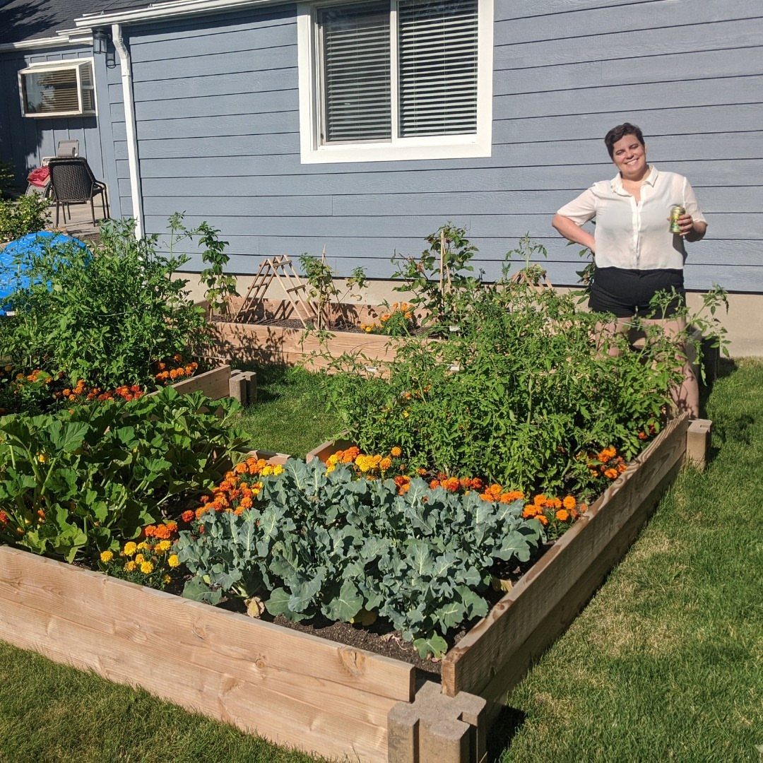 Easy Raised Garden: 9 Ideas for Any Budget and Skill Level 8 Wooden raised garden beds filled with green vegetables and orange flowers on a sunny lawn.