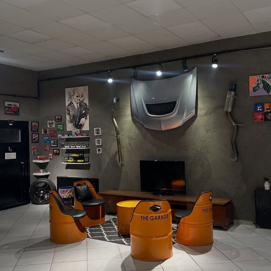 9 Garage Design Interior Ideas for Workspace, Storage and Style 9 Orange drum-shaped chairs and a stool arranged in a themed automotive lounge area.