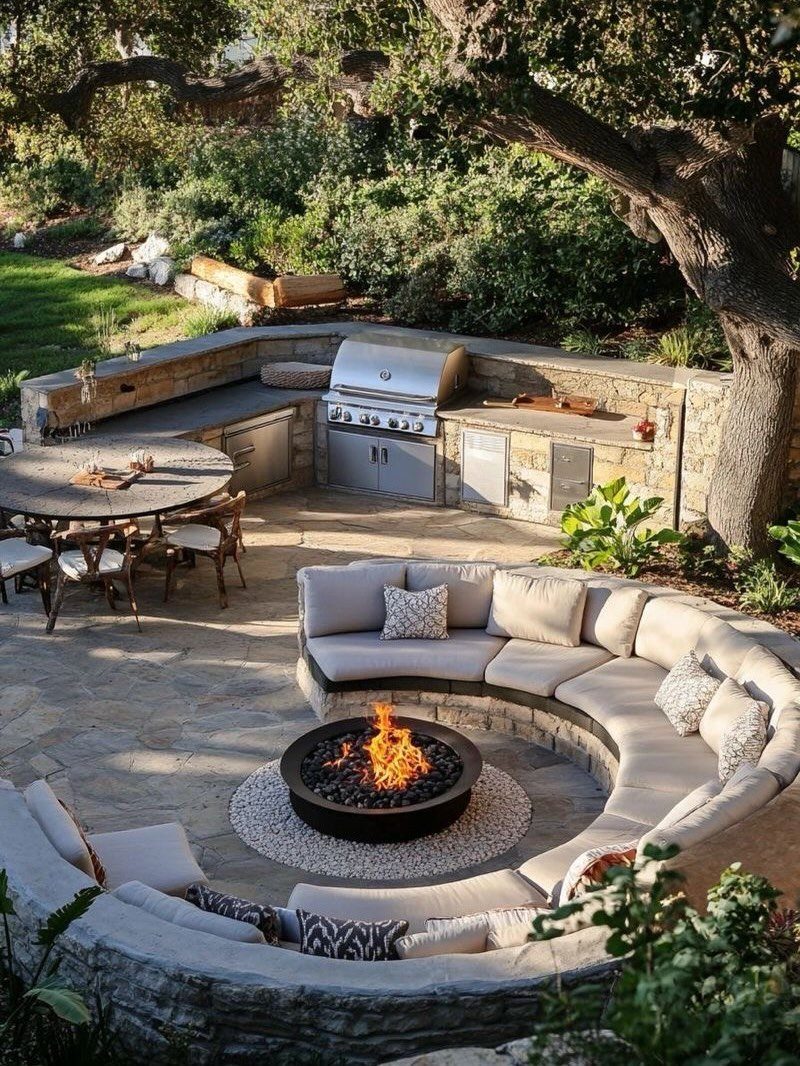 22 Backyard Garden Ideas for Patios, Beds, and Privacy 2 A circular stone seating area with cushions surrounding a lit fire pit on a patio.