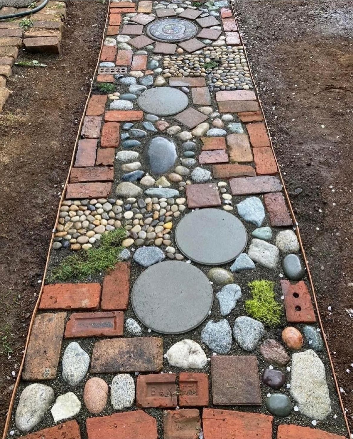 22 Backyard Garden Ideas for Patios, Beds, and Privacy 9 A mosaic garden path featuring red bricks, large circular stepping stones, and small river pebbles.