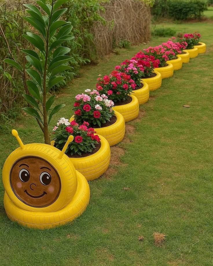 22 Backyard Garden Ideas for Patios, Beds, and Privacy 13 Yellow caterpillar-shaped planters filled with pink flowers lined up on a green grass lawn.