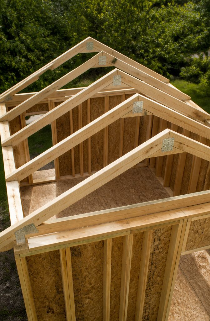 How to Build a Shed: 7 Steps From Foundation to Finished Exterior 5 Roof trusses arranged for installation on top of the shed walls.