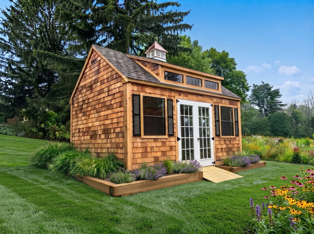 9 Modern Farmhouse Shed Ideas for Your Backyard 4 Cedar shingle shed with white French doors and black shutters sitting on a green lawn.