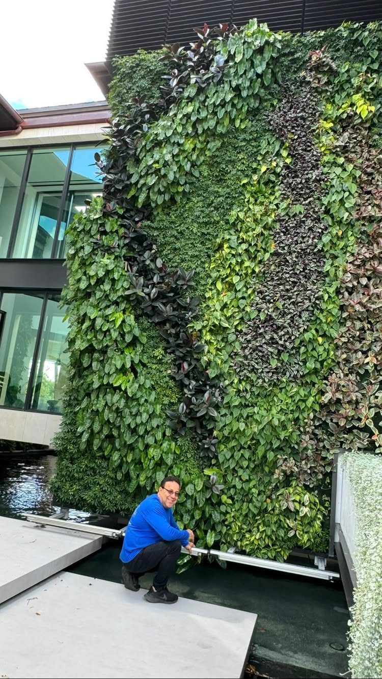 29 Outdoor Gardens Ideas for Patios, Yards, and Every Budget 25 A lush vertical living wall with green and purple foliage next to a modern building.