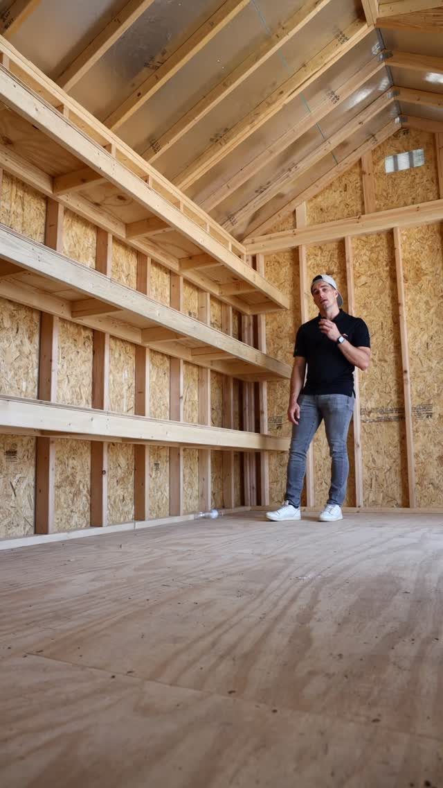 Tool Shed Storage: 12 Ideas for Lawn Gear, Power Tools & Hardware 12 A man standing inside a wooden shed featuring empty built-in plywood shelving units.