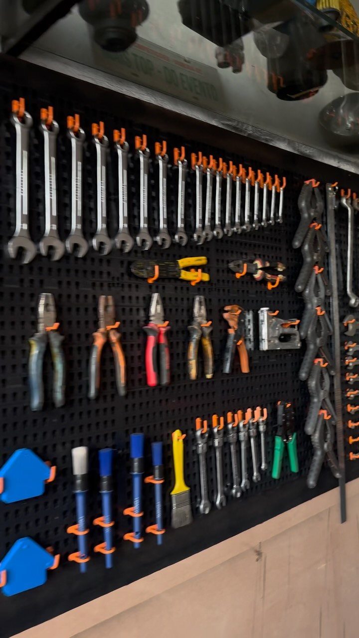 Tool Shed Storage: 12 Ideas for Lawn Gear, Power Tools & Hardware 2 Various hand tools organized on a black pegboard with orange hooks in a workshop.