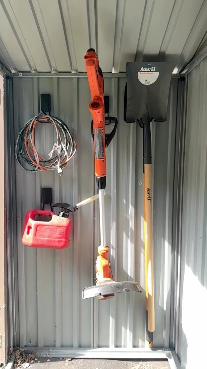 Tool Shed Storage: 12 Ideas for Lawn Gear, Power Tools & Hardware 9 String trimmer, shovel, gas can, and extension cord hanging on hooks inside a metal shed.