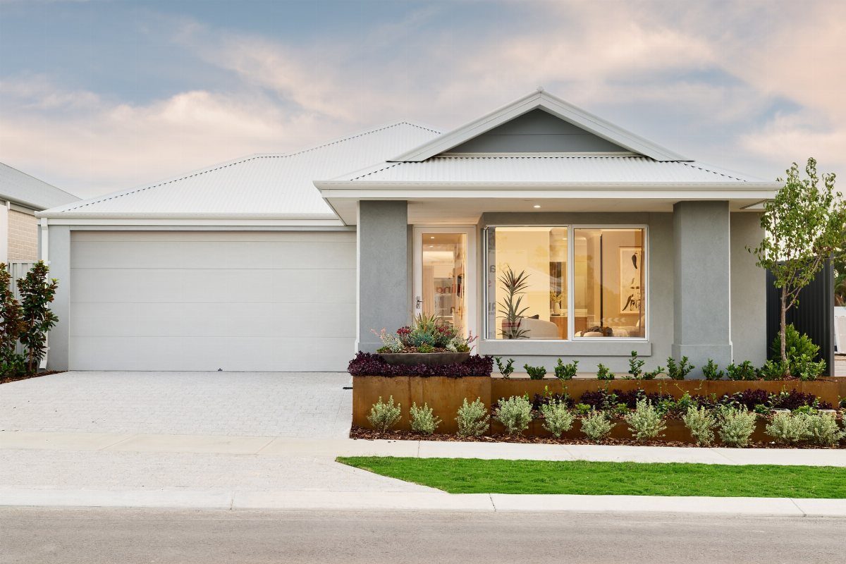 A white horizontal paneled garage door on a modern grey house with landscaping.